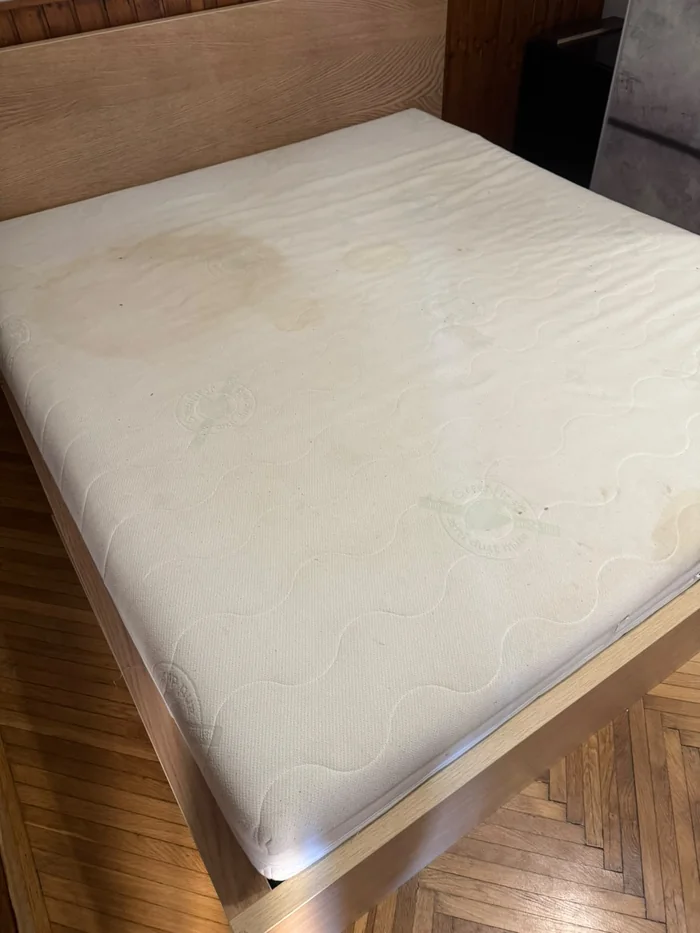 Mattress with yellow sweat and urine staining across the top panel, before cleaning, Budapest flat