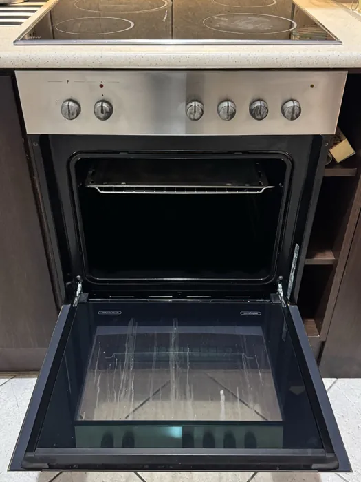 Cleaned oven with the door open, glass and shelves clear